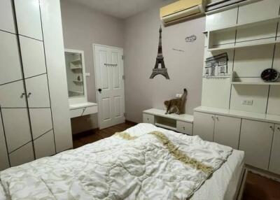 Bedroom with white furniture, a bed, and wall decor