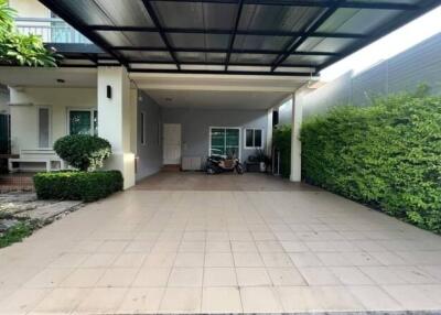 Covered garage area with green surroundings