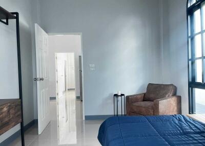 Modern bedroom with armchair and blue bedspread