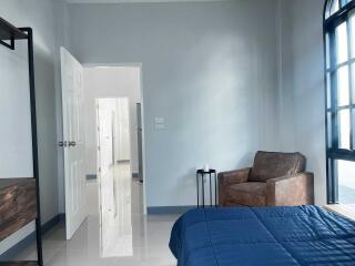 Modern bedroom with armchair and blue bedspread