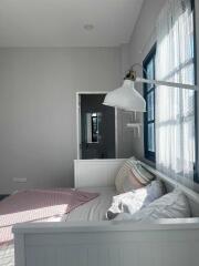 Bright bedroom with white furniture and large window