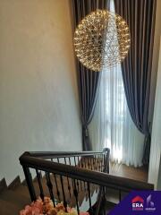 Elegant staircase with large window and modern chandelier