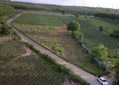 Aerial view of an expansive land area with fields and a road