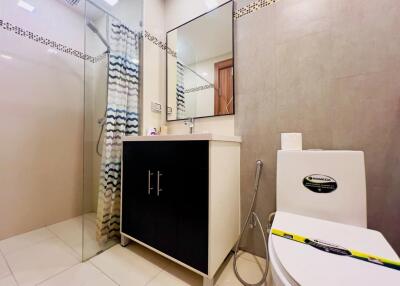 Modern bathroom with shower, vanity, and toilet