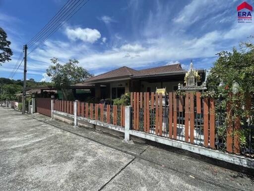 Exterior view of a residential building with a fenced yard