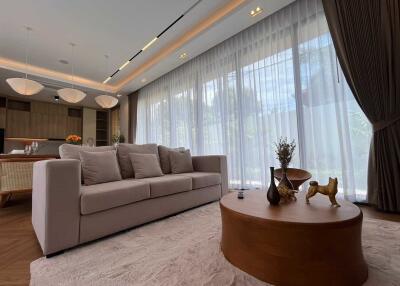 Spacious living room with comfortable sofa, coffee table, and large windows