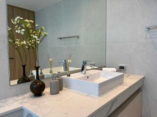 Modern bathroom with marble countertop and floral decor