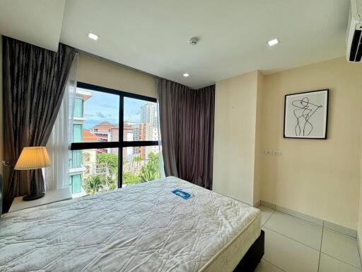 Modern bedroom with large window and abstract artwork