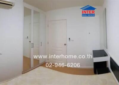 Bedroom with white walls, mirrored wardrobe, air conditioner, and minimal furnishing.