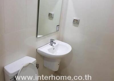 Clean bathroom with toilet, sink, and mirror