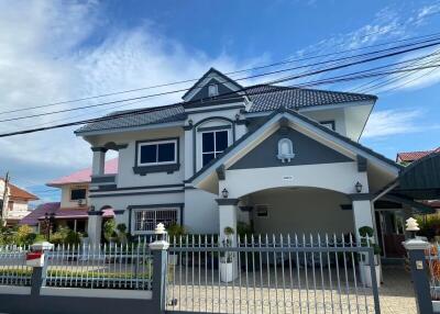 Front view of a modern two-story house with a fenced yard