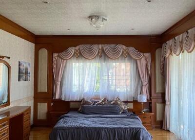 Spacious bedroom with wooden accents and large windows