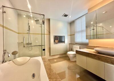 Modern bathroom with glass shower, bathtub, and large vanity mirror