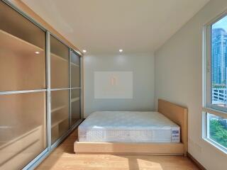 Spacious bedroom with a bed and large closet with sliding doors