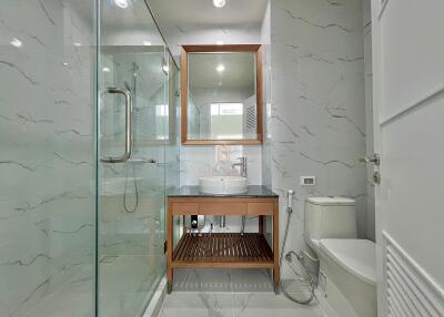 Modern bathroom with glass shower and wooden accents