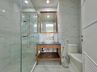 Modern bathroom with glass shower and wooden accents