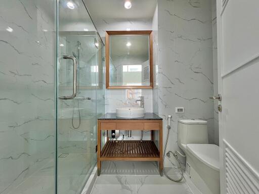 Modern bathroom with glass shower and wooden accents