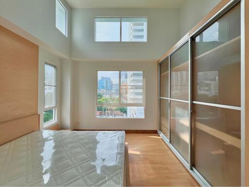 Modern bedroom with large windows and built-in closets