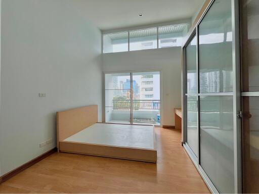 Bright bedroom with wooden flooring and large windows