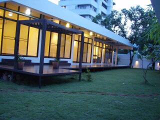 Modern building with large windows and patio in the evening