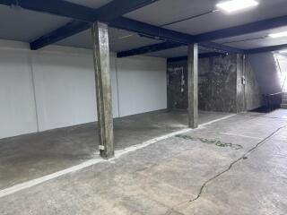 spacious basement area with concrete pillars and industrial finish