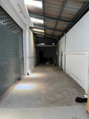 Empty warehouse space with concrete floor and metal roofing.