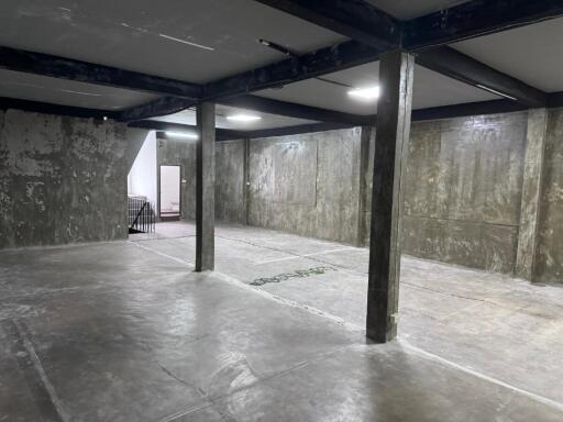 Spacious unfinished basement with concrete floors and exposed beams