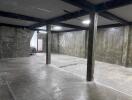 Spacious unfinished basement area with concrete floors and walls