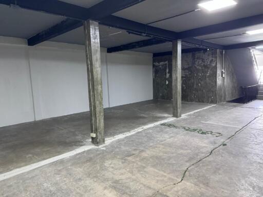 Spacious and empty basement area with concrete floors and support columns