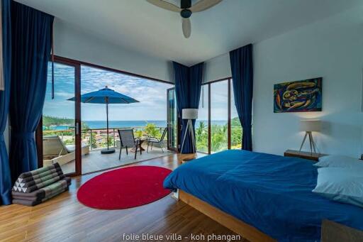 Spacious bedroom with sea view, balcony, and modern decor