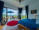 Spacious bedroom with ocean view, balcony access, and modern decor