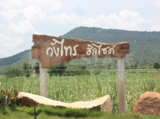 Scenic exterior view with a large wooden sign in a rural landscape