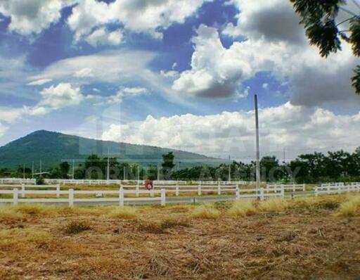 Scenic view of a rural area with mountain and clouds