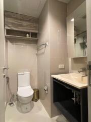 Modern bathroom with toilet, sink, and vanity mirror