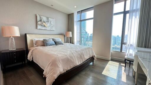 Spacious modern bedroom with large windows and city view