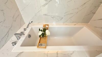 Modern bathroom with marble tiles and a bathtub