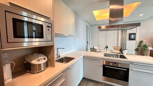 A modern kitchen with integrated appliances and dining area