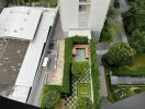 Aerial view of modern apartment complex with greenery and rooftop gardens