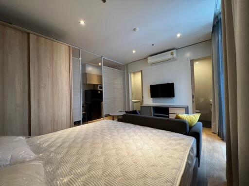Modern bedroom with bed, couch, TV, and wardrobes