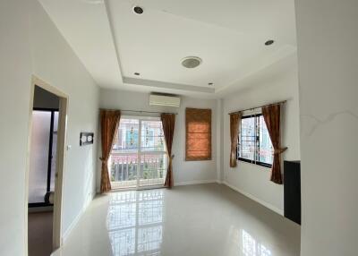 Spacious living room with windows and curtains allowing natural light