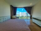 Large bedroom with a panoramic window and city view