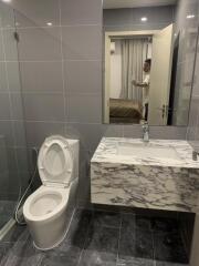 Modern bathroom with toilet, sink, and marble countertop