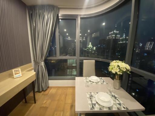 Night view of a cozy dining area with a table set for two near large windows