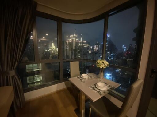 Night view from a cozy apartment dining area with city skyline