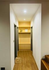 Well-lit modern hallway with wooden floor and built-in shelving
