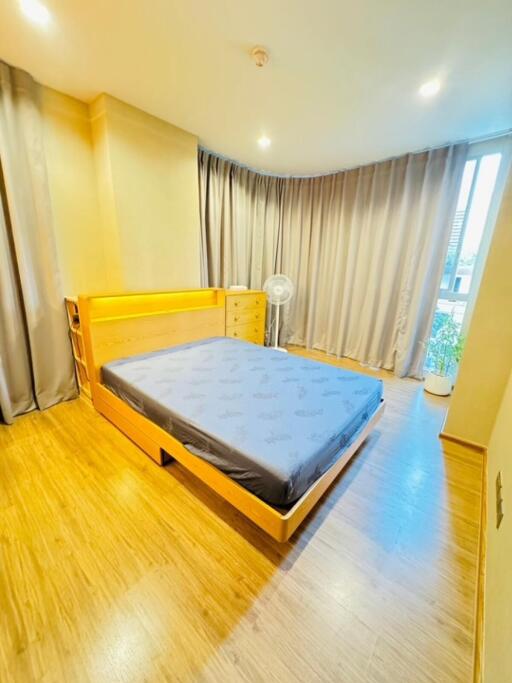 Bright bedroom with wooden floor and large window