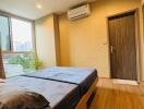 Modern bedroom with wooden flooring and large window view