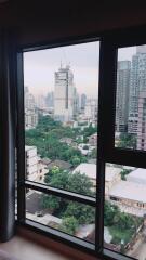 View from the window of a high-rise building showing a cityscape with construction and greenery