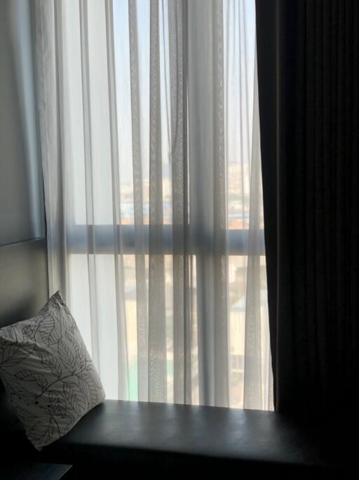 Window view with curtains and pillow on bench