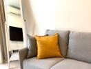 Modern living room with a grey sofa and yellow pillow